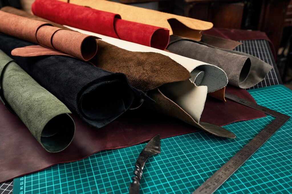 Rolled up samples of textures of genuine leather of different colors on a leather background, on a