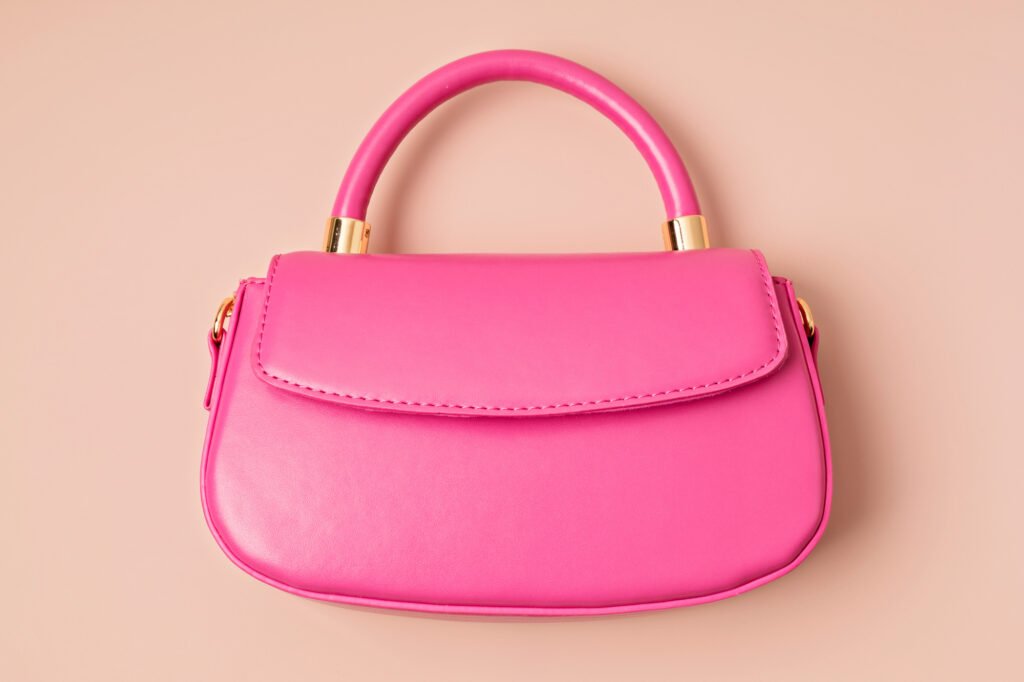 Pastel colored womens hand bag on pink background