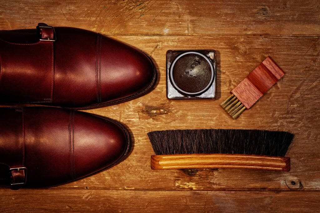 Still life with men's leather shoes and accessories for shoes care.